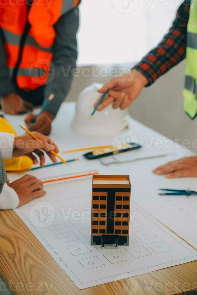 conceito de construção e estrutura de reunião de engenheiro ou arquiteto para projeto trabalhando com parceiros e ferramentas de engenharia na construção de modelo e projeto no local de trabalho, contrato para ambas as empresas. foto