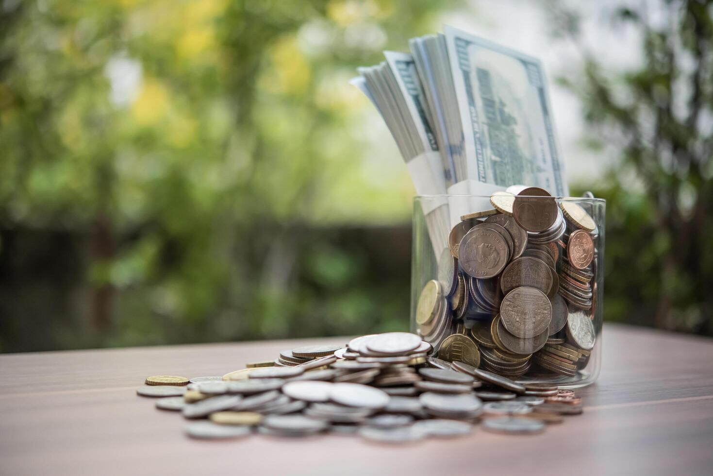 grupo de moedas e notas de euro em uma jarra de vidro. foto