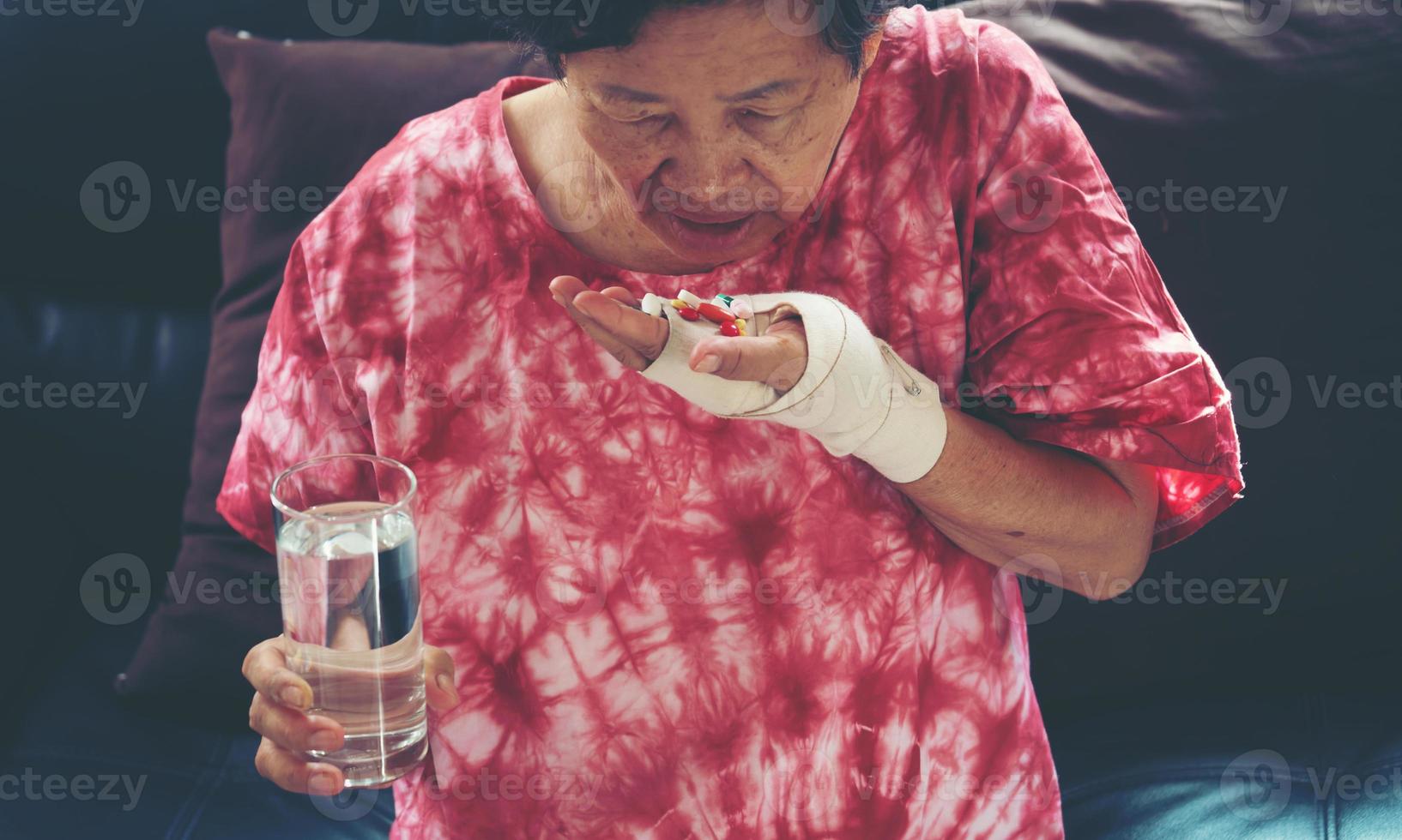 mulher asiática sênior tomando remédio pílula disponível foto