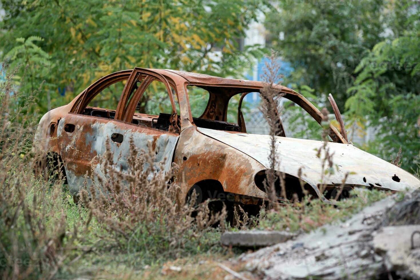 queimado Fora estourado acima carro contra a fundo do uma destruído casa guerra entre Rússia e Ucrânia foto