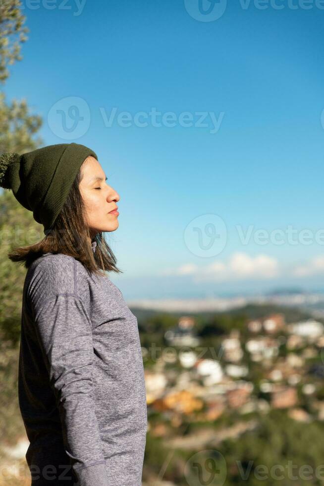 mulher relaxa dentro a garraf natural parque e recebe a do sol raios em dela face. foto