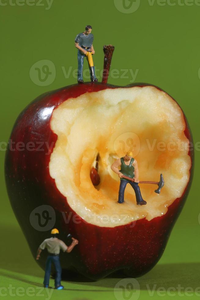 trabalhadores da construção civil em imagens conceituais com uma maçã foto