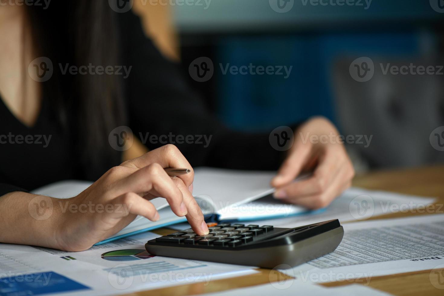 os funcionários do escritório usam a calculadora para calcular os dados na mesa do escritório. foto