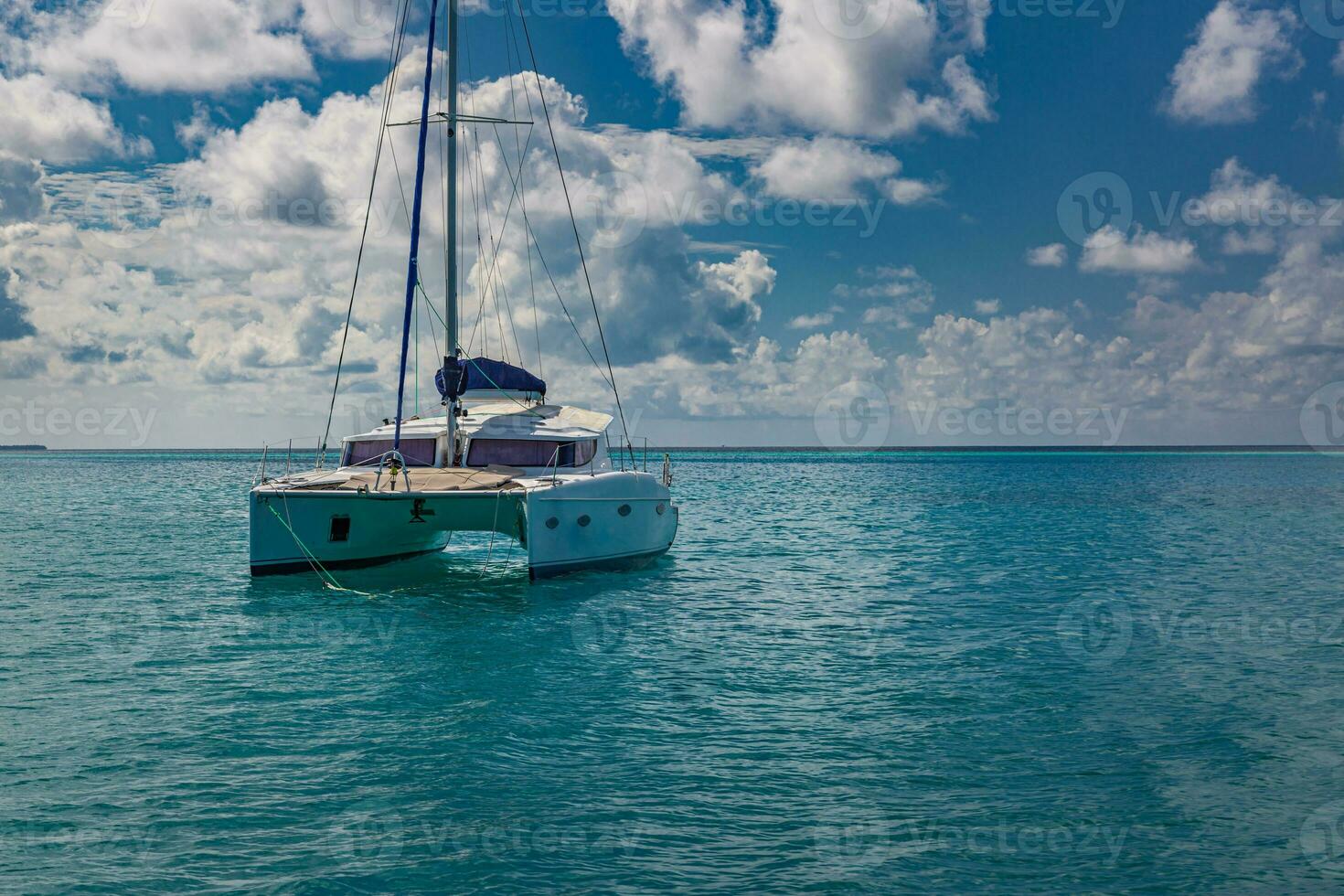 iate de luxo em águas abertas com belas nuvens. veleiro catamarã branco na lagoa do oceano tropical, horizonte do mar sob o horizonte ensolarado. esporte ao ar livre idílico e paisagem de recreação de viagens, marinha foto