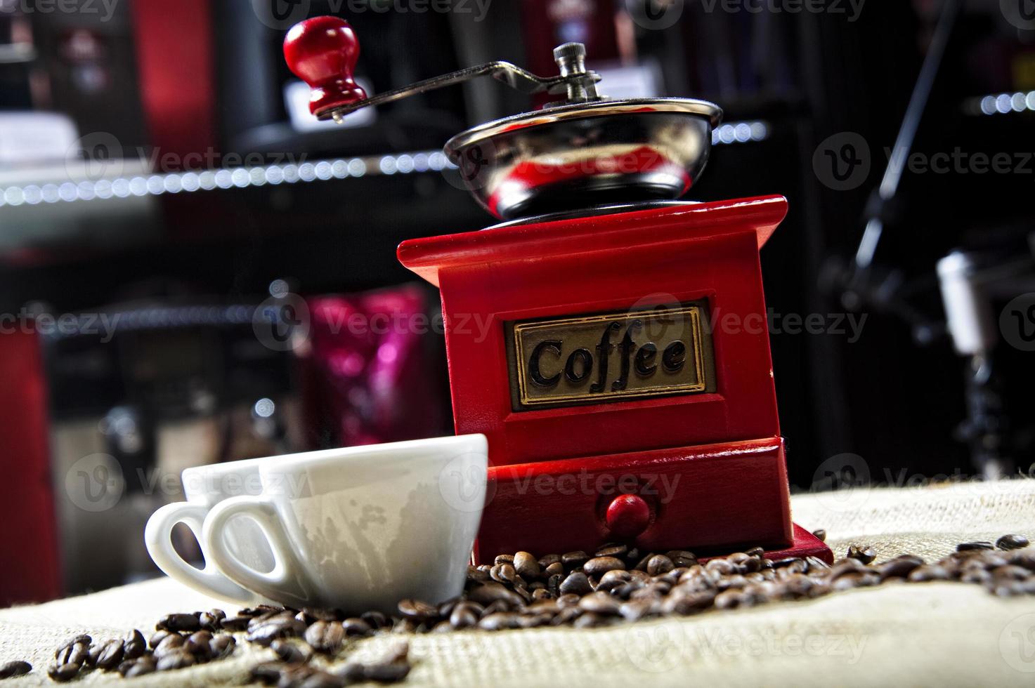 foto de um moedor de café vintage vermelho com duas xícaras de café