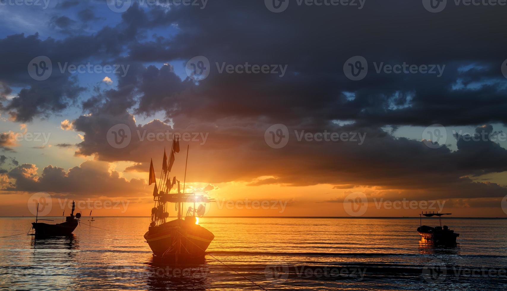 silhueta de barcos de pesca na hora do sol. foto