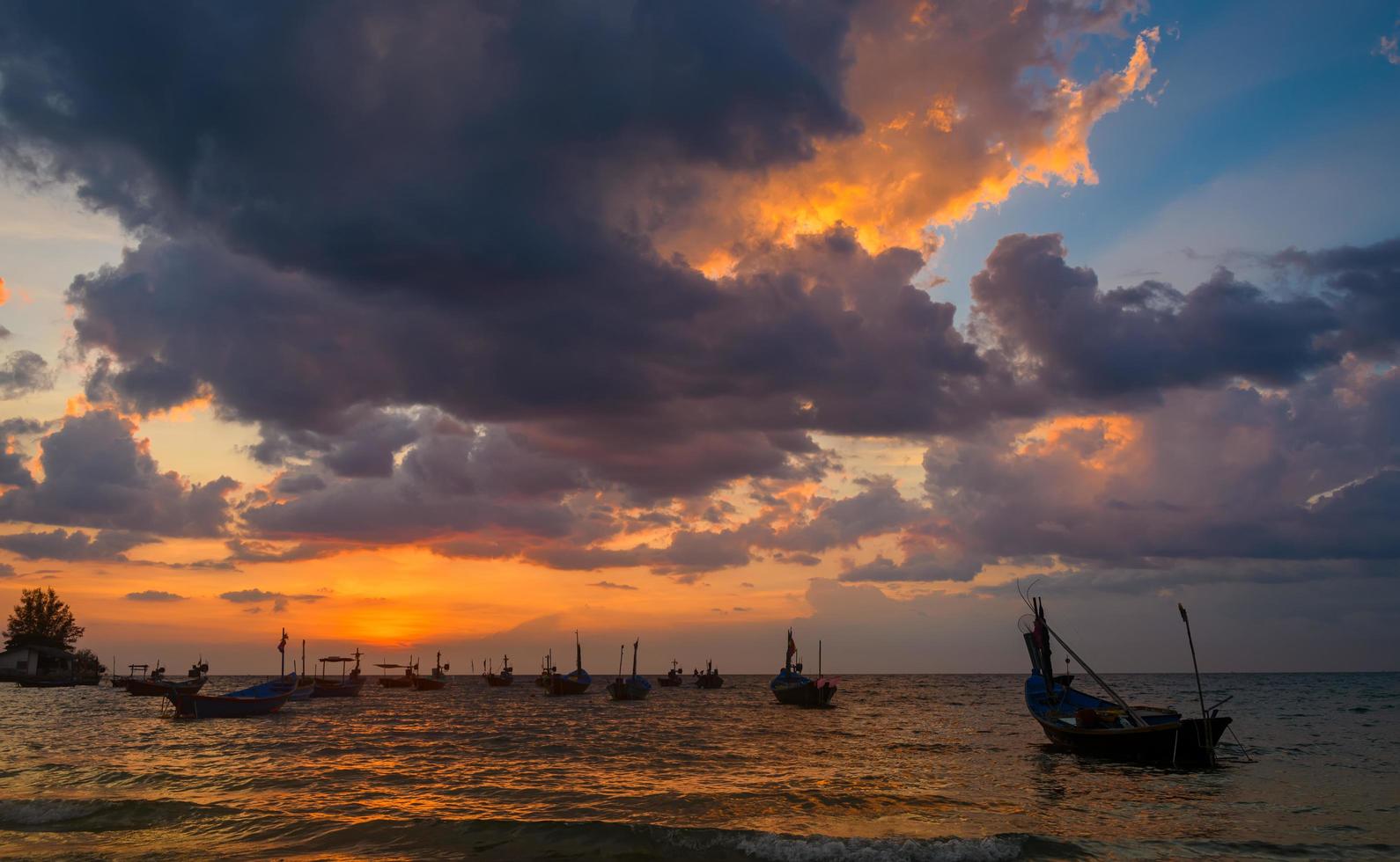 silhueta de barcos de pesca na hora do sol. foto