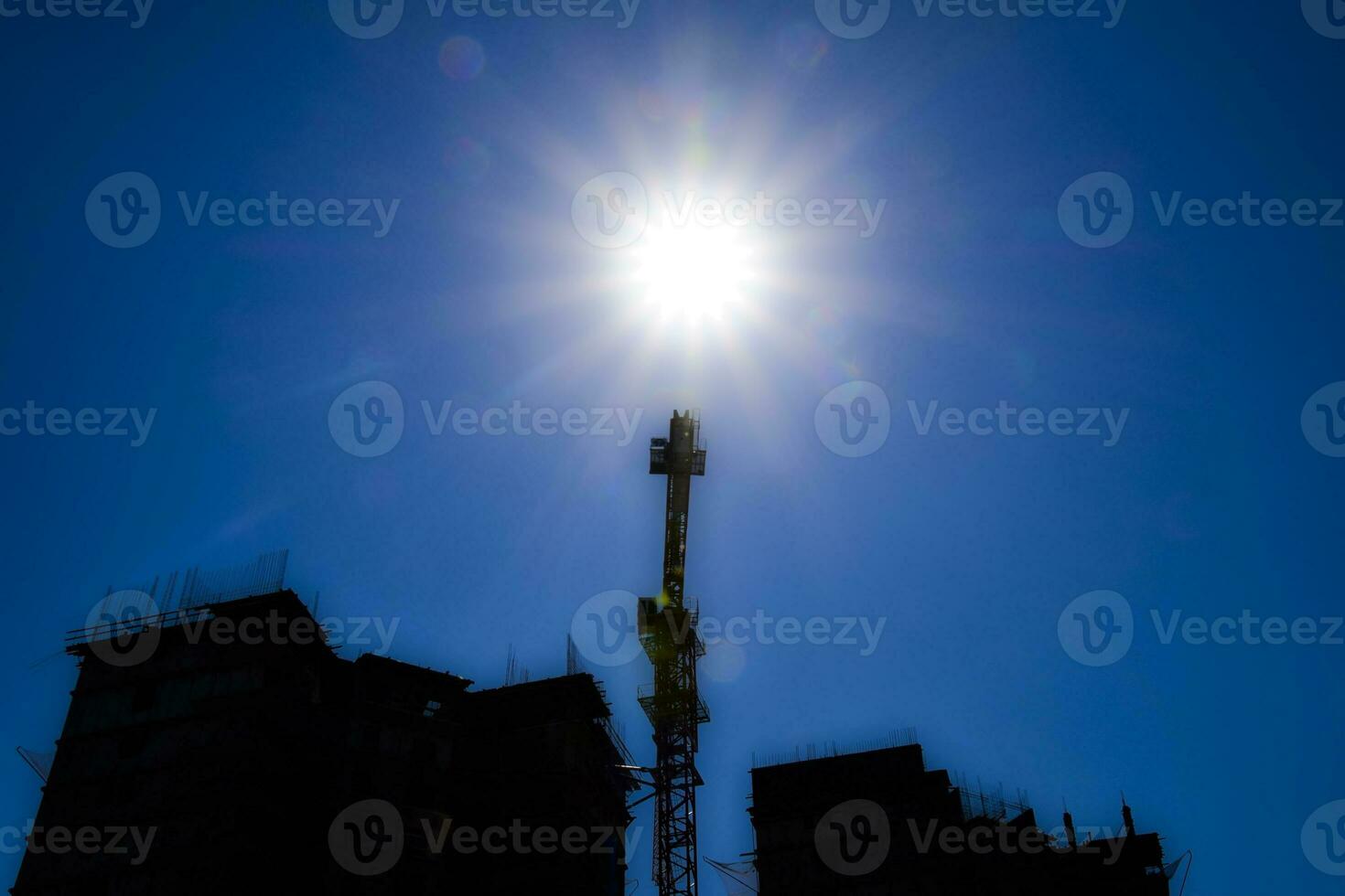 construção debaixo construção e uma construção guindaste contra a céu e a Sol foto