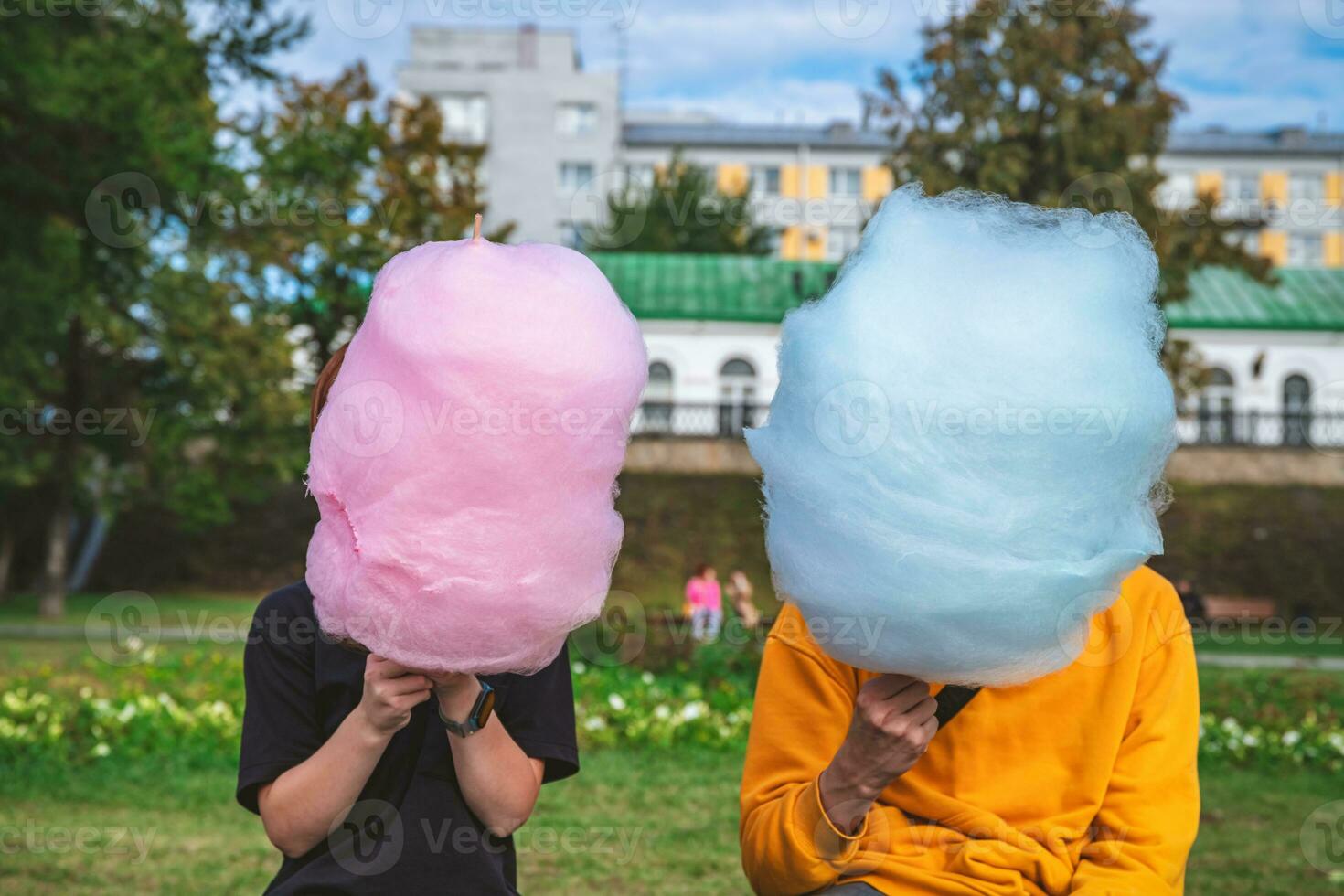 dois crianças estão sentado com uma ampla algodão doce azul e luz azul. irmão e irmã, andar, infância, doces foto