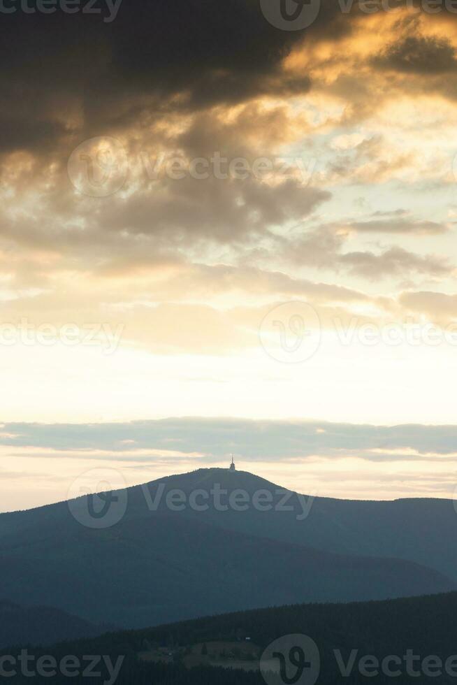 dramático pôr do sol com chuvoso nuvens sobre Lisa hora pico beskydy montanhas, tcheco república foto