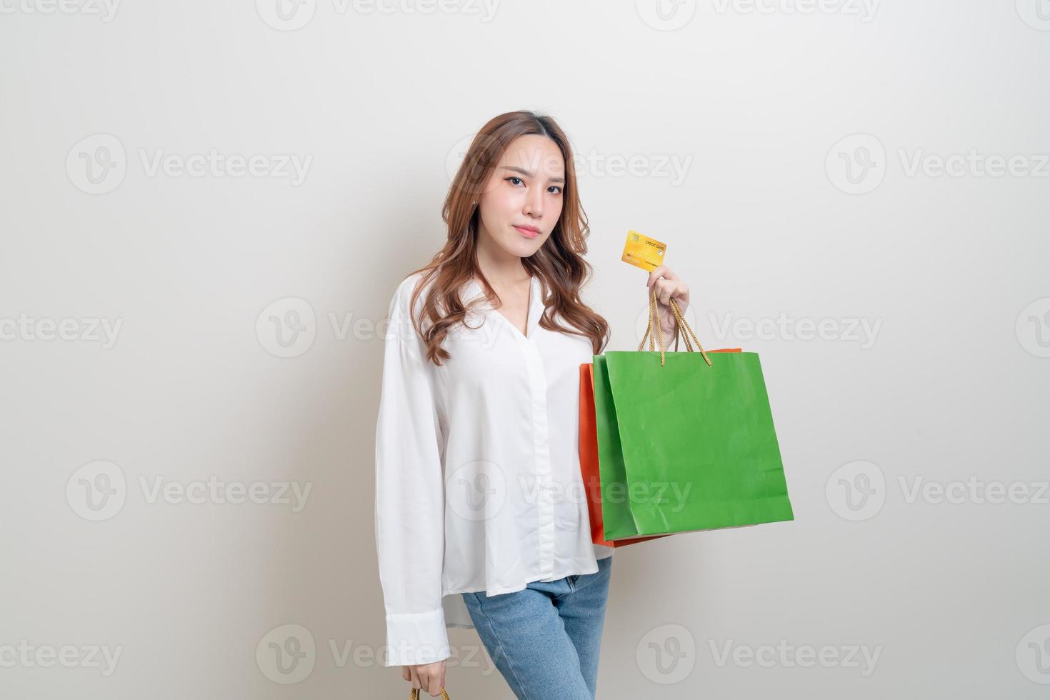 retrato de uma mulher bonita segurando uma sacola de compras e um cartão de crédito foto