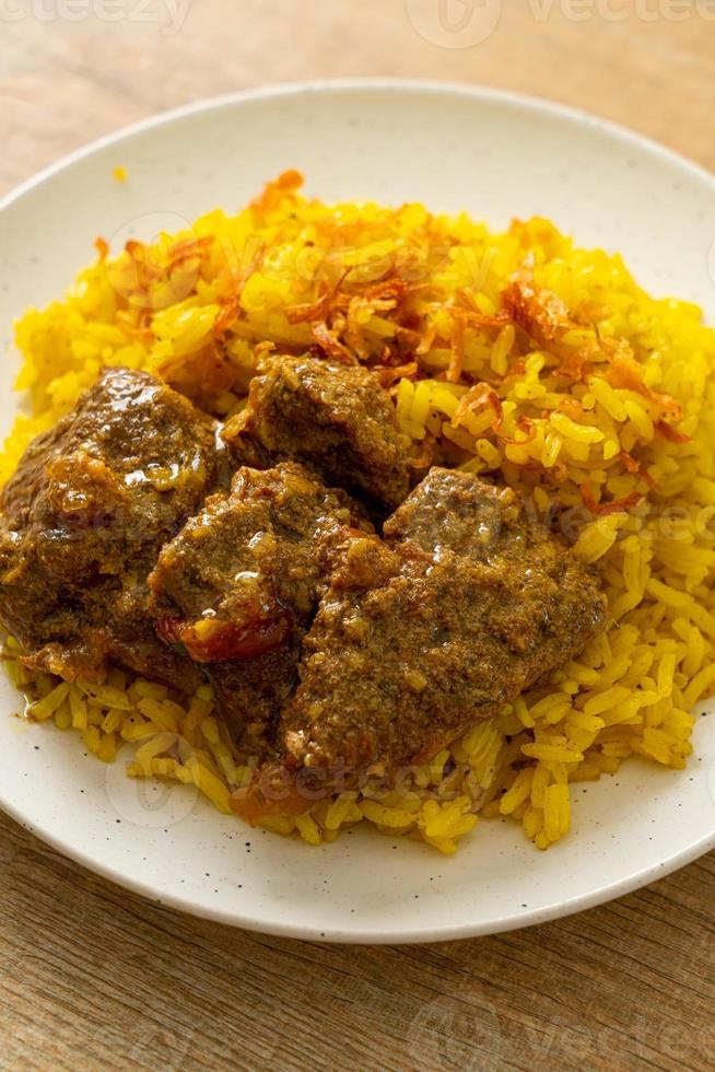 biryani de carne ou arroz com curry e carne - versão tailandês-muçulmana do biryani indiano, com arroz amarelo perfumado e carne bovina foto