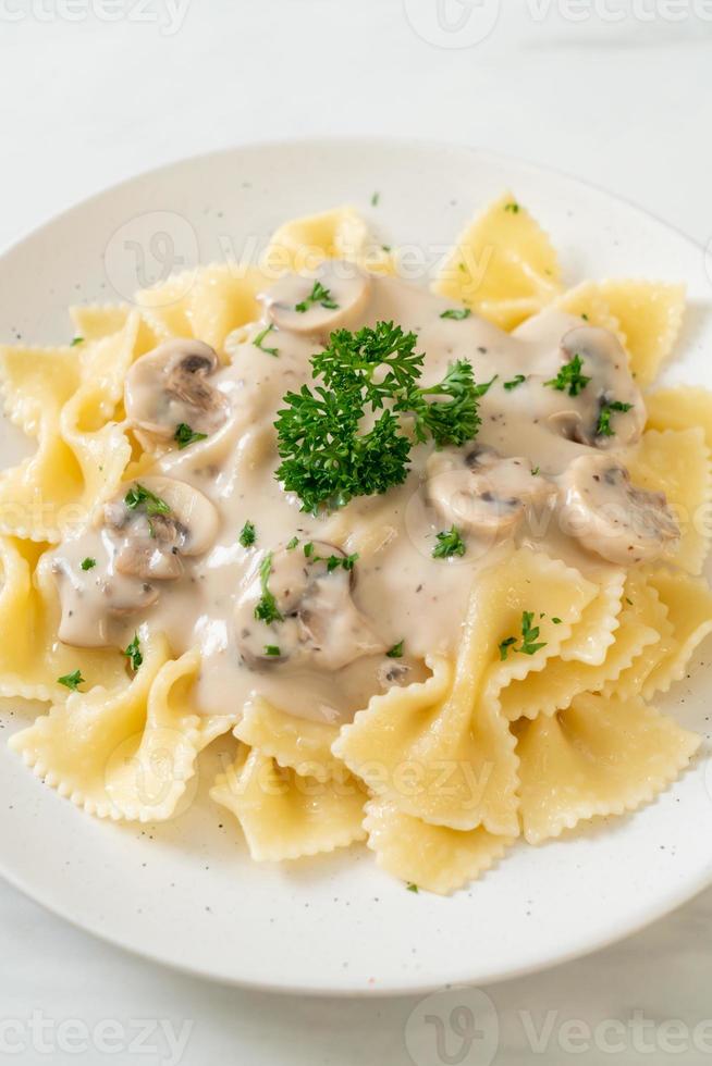 macarrão farfalle com molho de creme de cogumelos branco foto