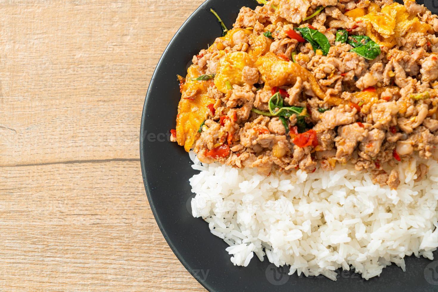 Carne de porco picada frita com manjericão e ovo coberto com arroz foto