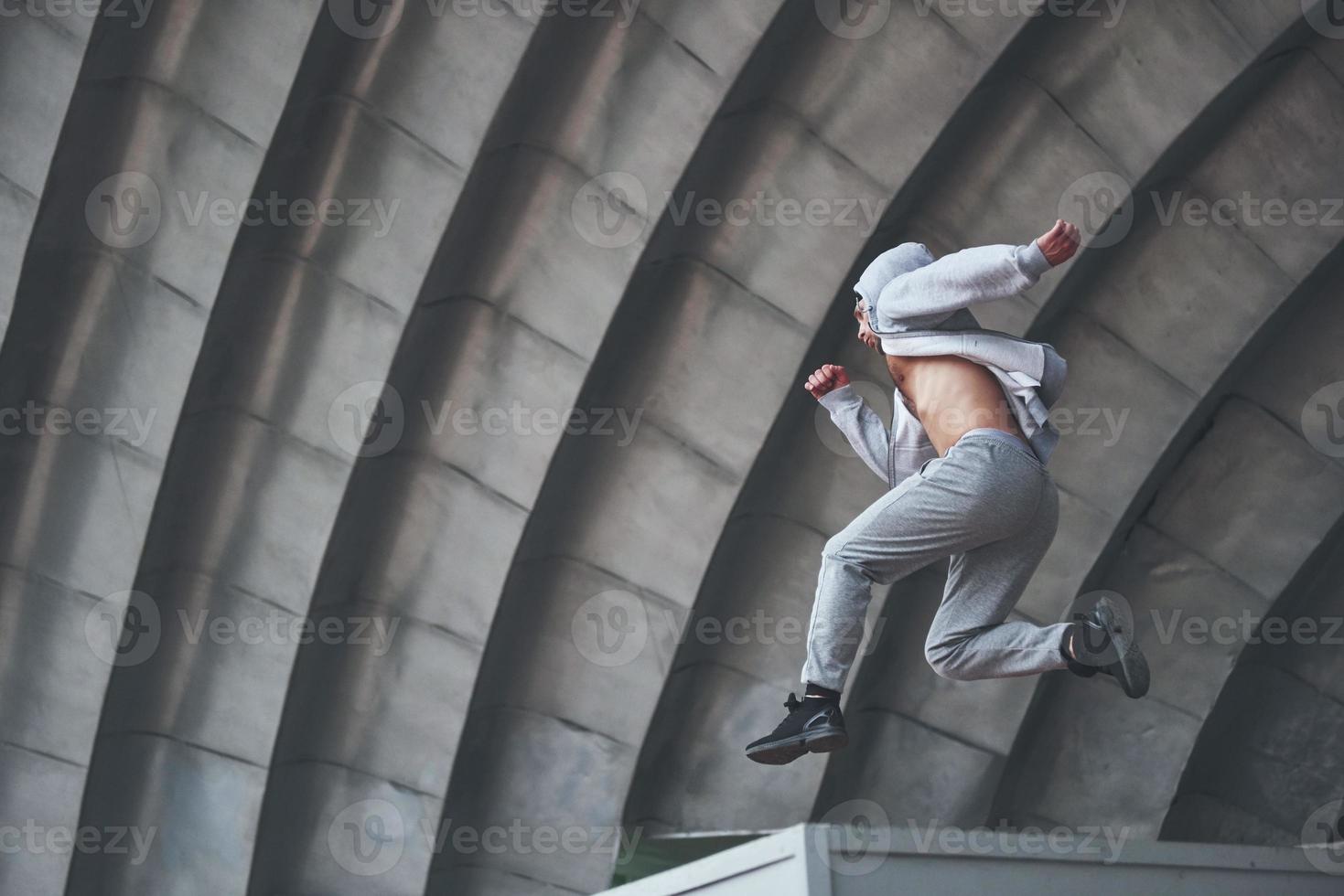 um jovem está pulando. parkour no espaço urbano, atividade esportiva. foto