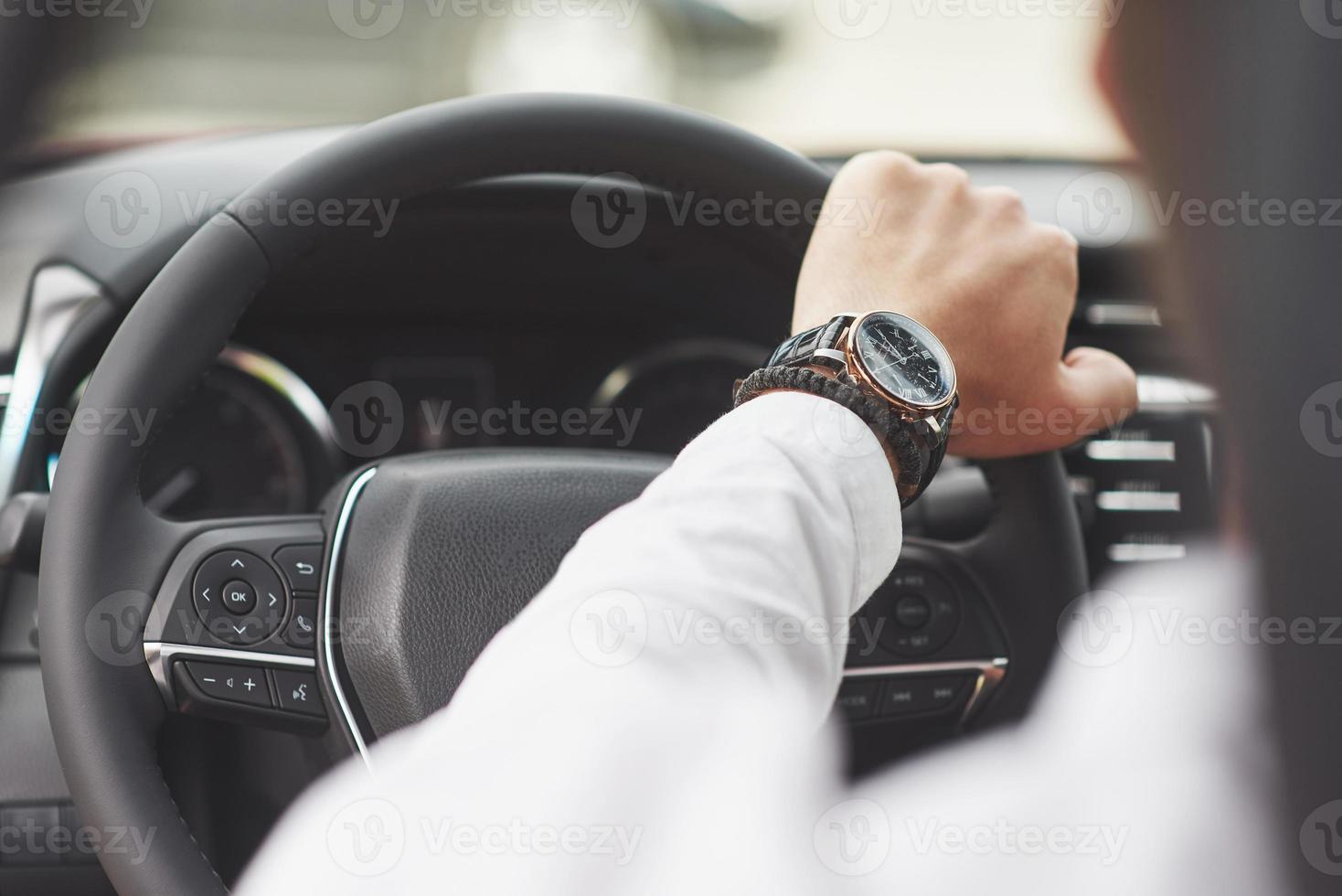 um empresário anda de carro, move-se ao volante. mão com relógio foto