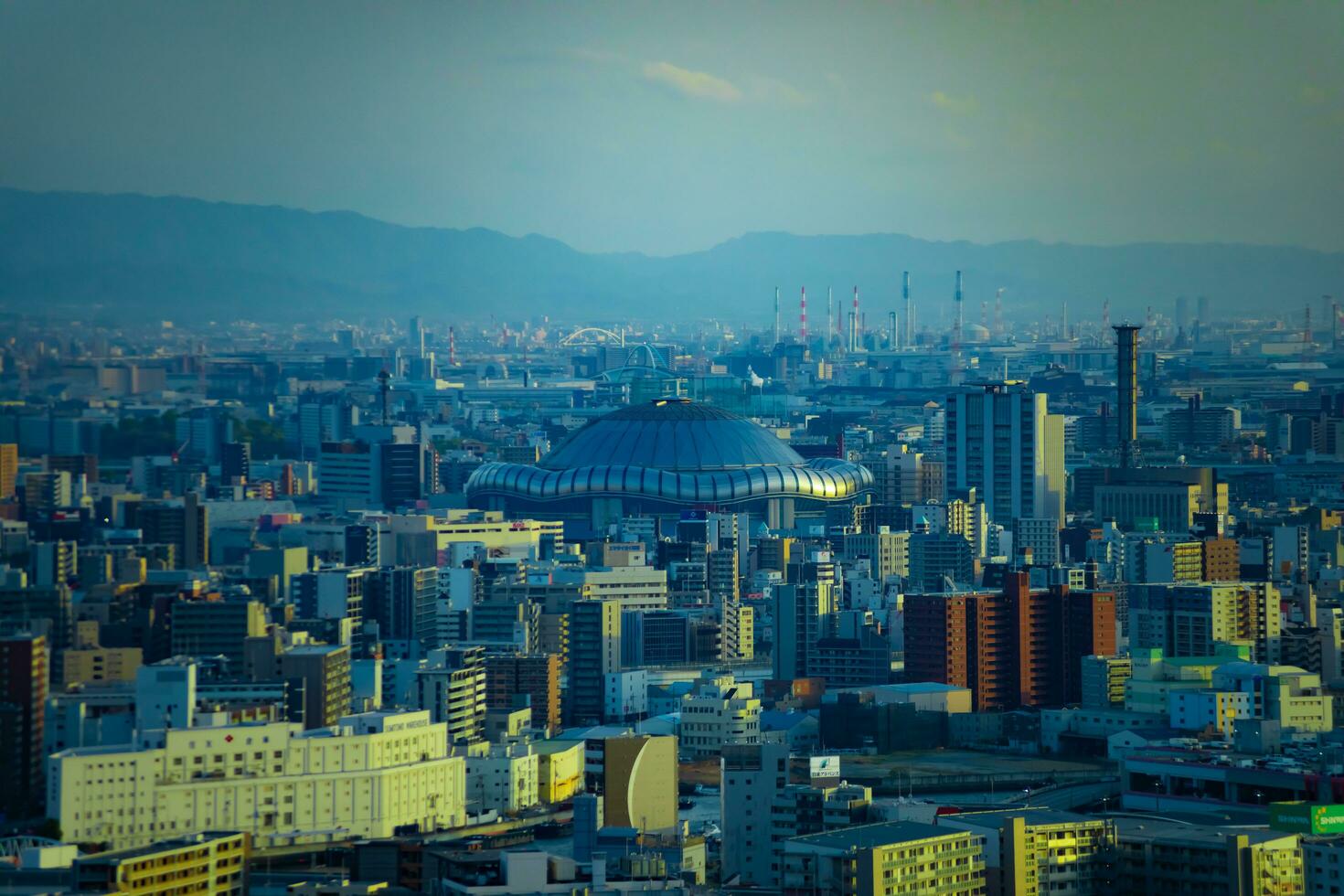 uma crepúsculo paisagem urbana de Alto ângulo Visão perto Kyocera cúpula dentro Osaka telefoto tiro foto