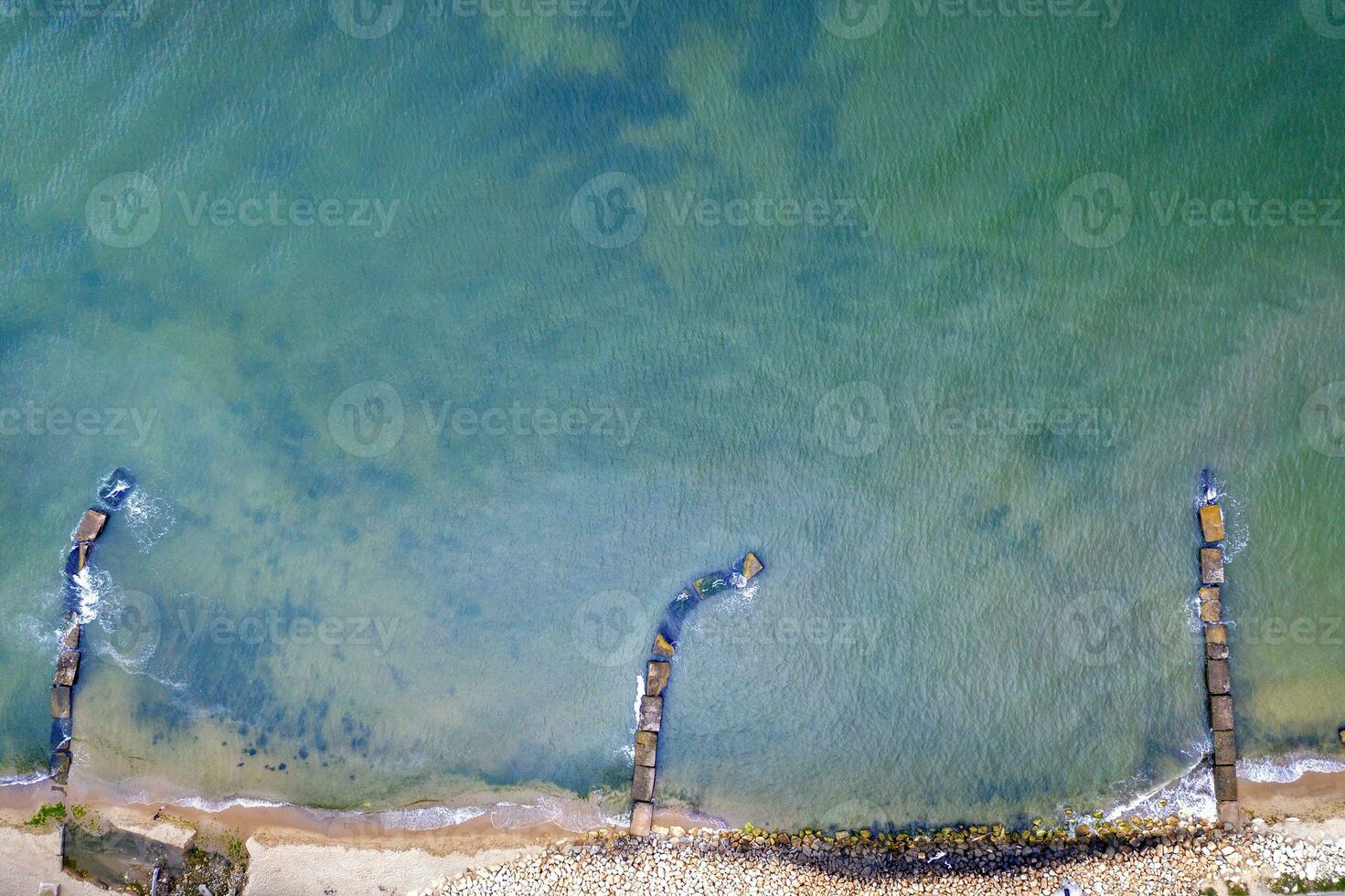 aéreo topo Visão a partir de zangão para a litoral e velho concreto cais. mar fundo. foto