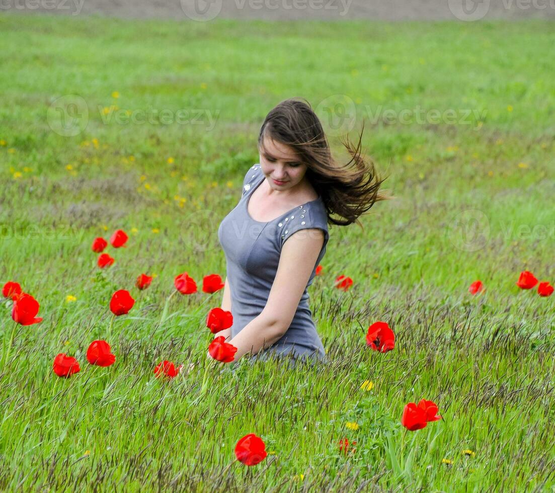 lindo fada jovem menina dentro uma campo entre a flores do tulipa foto