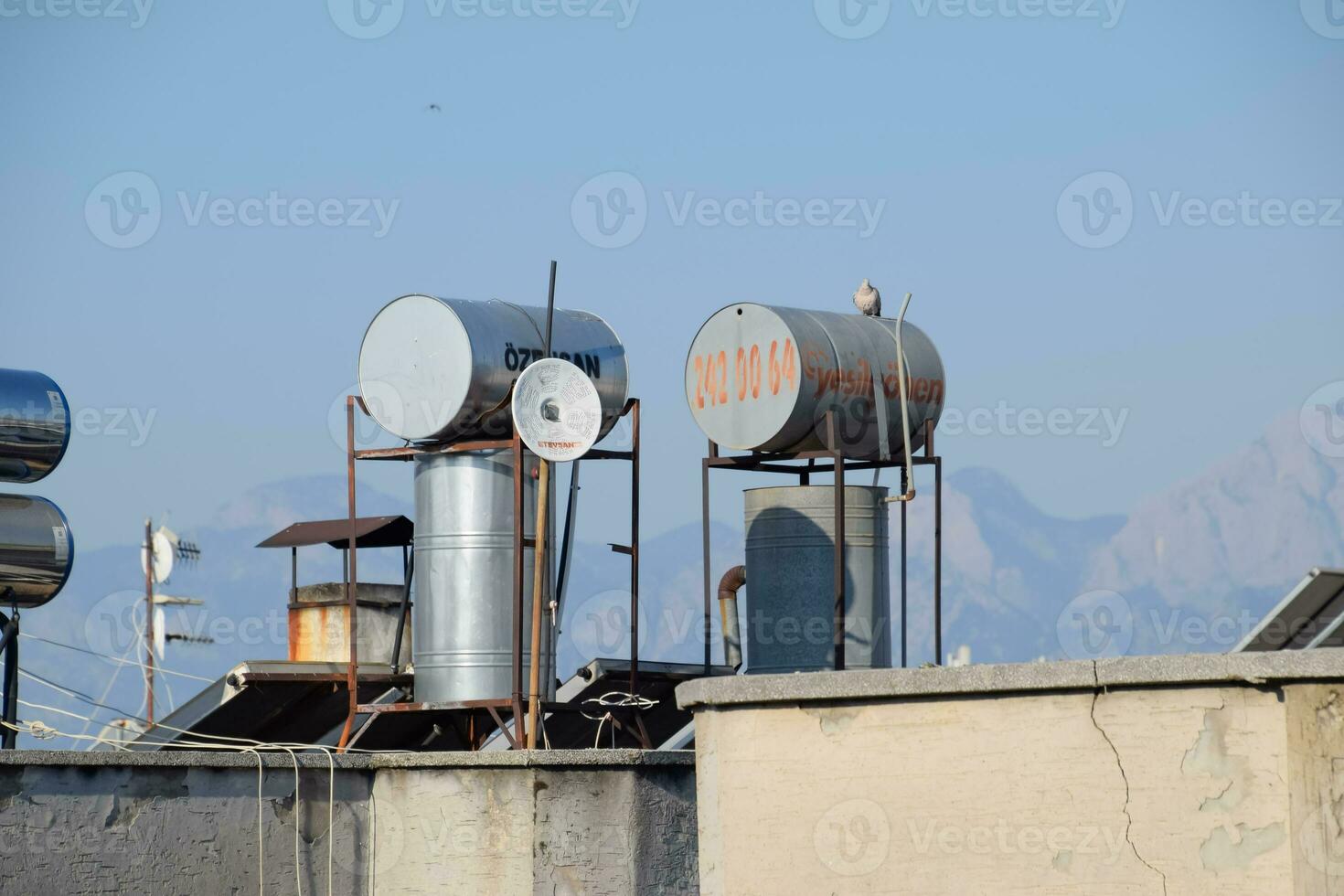 barris de aço de caldeiras com água no telhado de um edifício para aquecer água foto