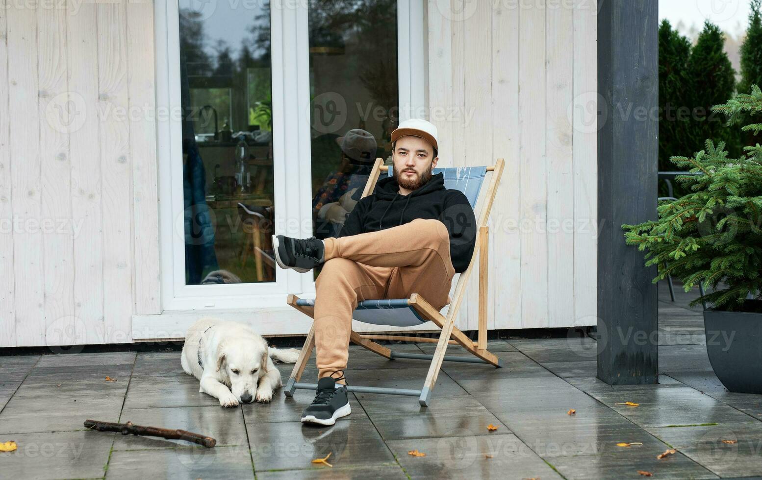 jovem homem sentado com cachorro em terraço foto