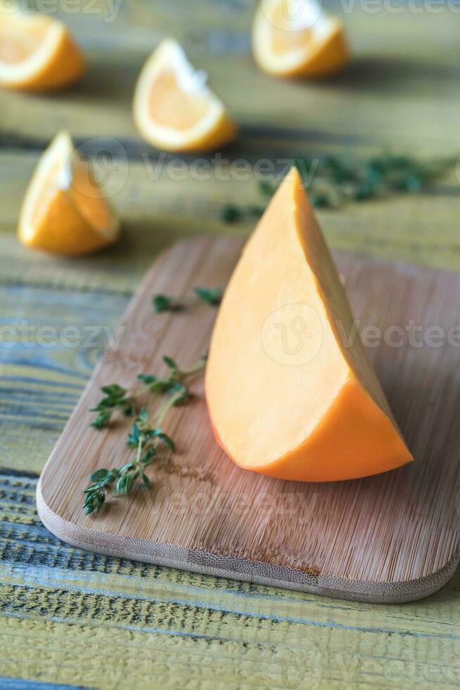 queijo mimolette na tábua de madeira foto