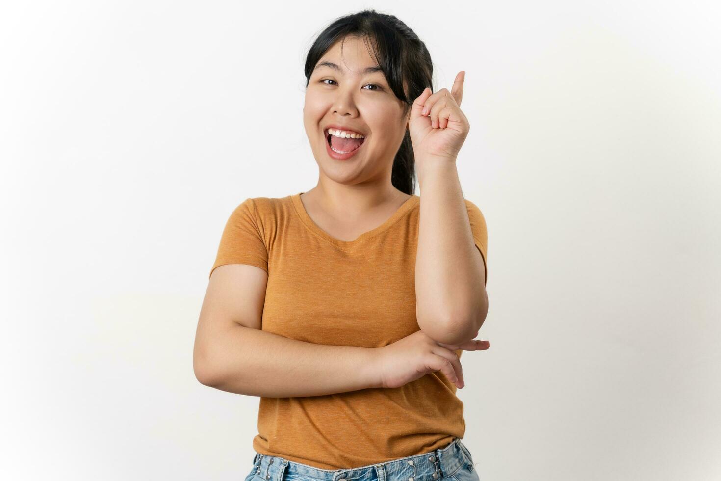 a alegre jovem ásia mulher tem ótimo pensamento, achando inspiração ou soluções para resolver uma problema. apontando dedo acima em pé em branco fundo. foto