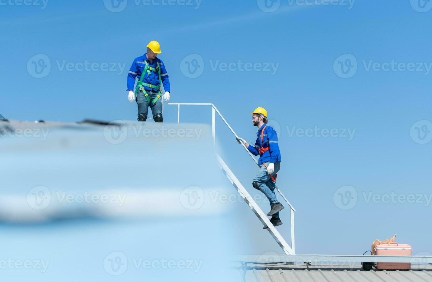 uma jovem técnico estagiário trabalhando em solar painéis é medo do alturas com Senior engenheiros quem estão sempre ajudando Fora foto