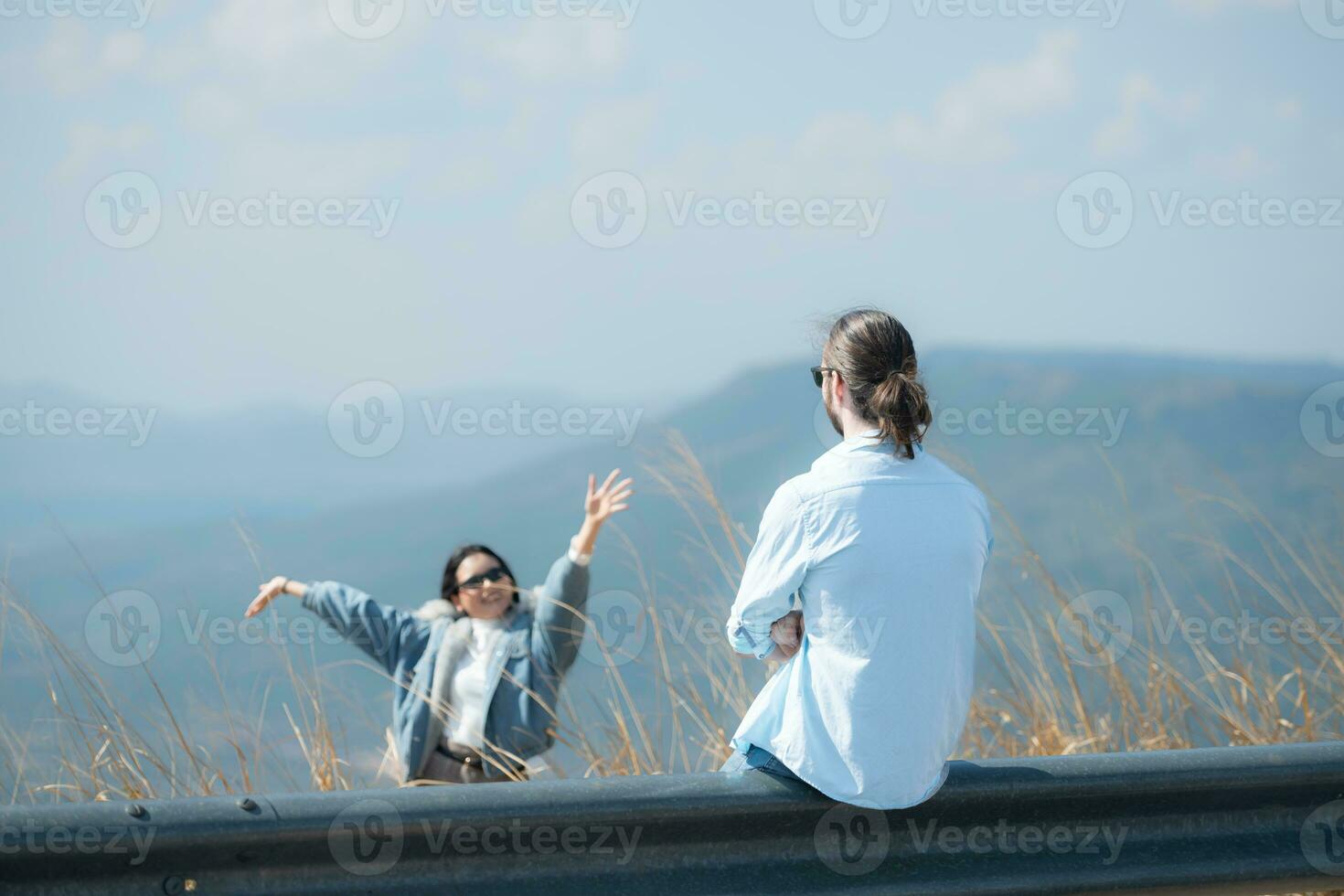 jovem casal relaxante em a topo do uma Colina dentro a montanhas foto