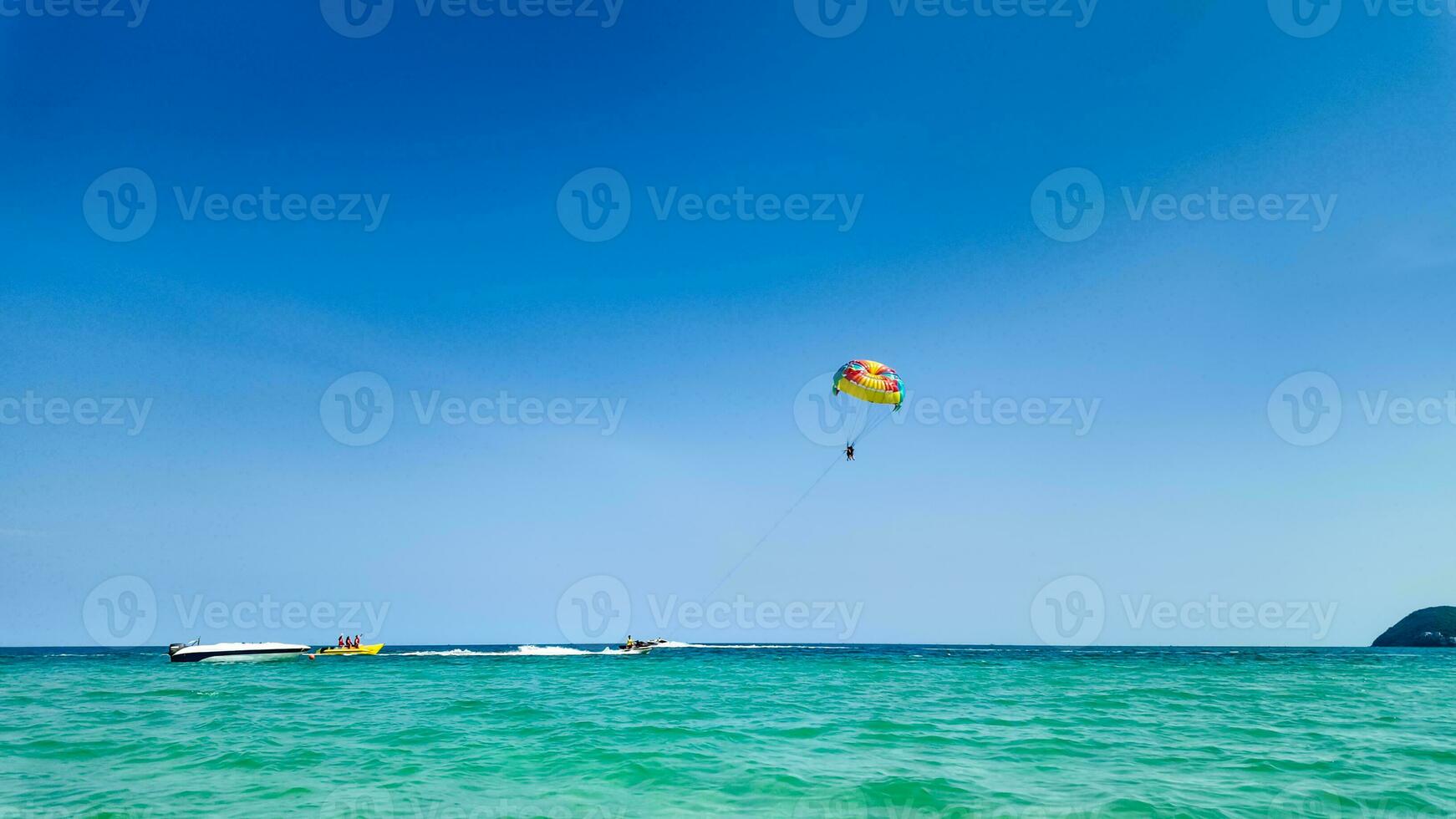iluminado pelo sol parasailing aventura sobre azul mares foto