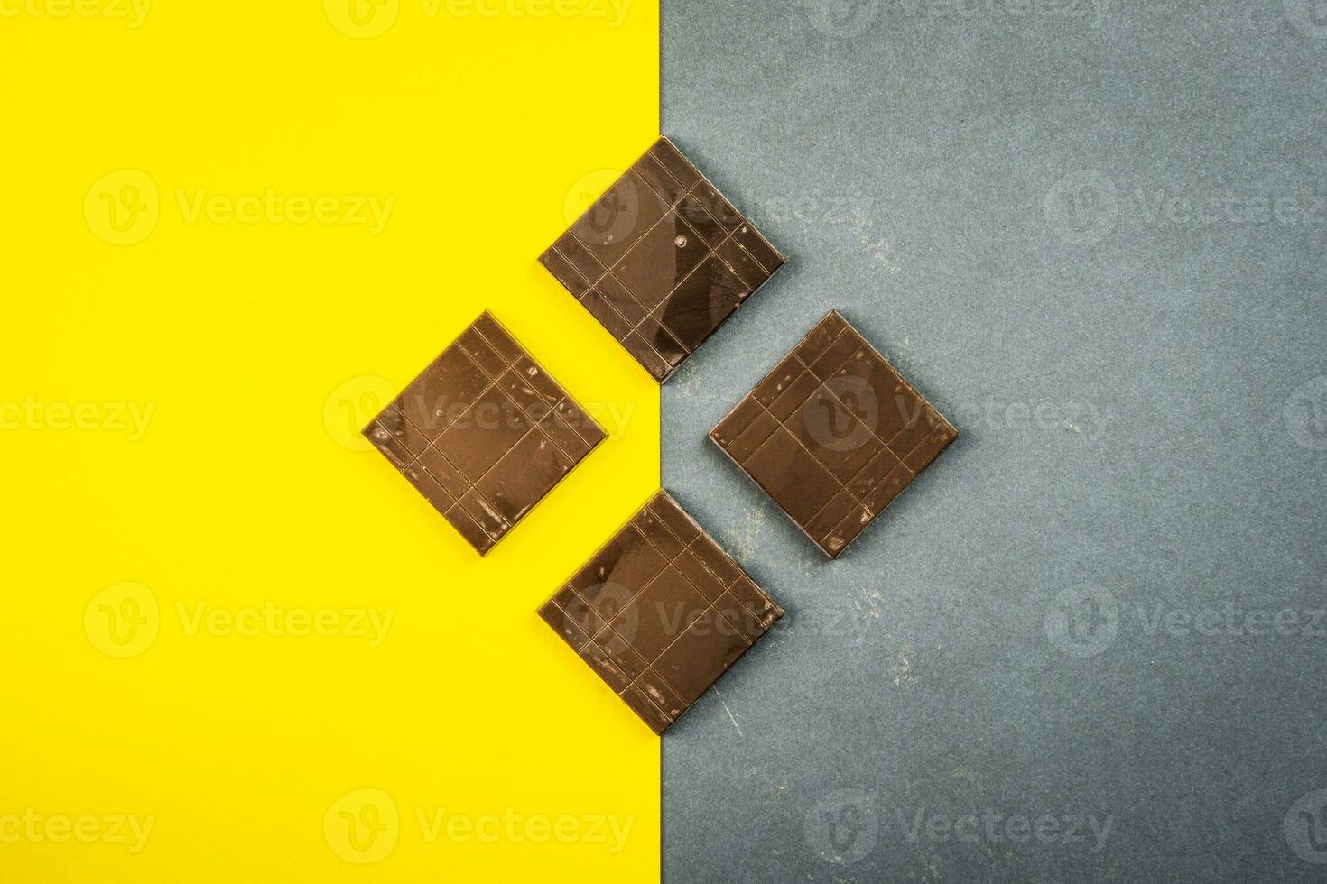 chocolate bares crio geométrico formas em uma amarelo e cinzento fundo foto