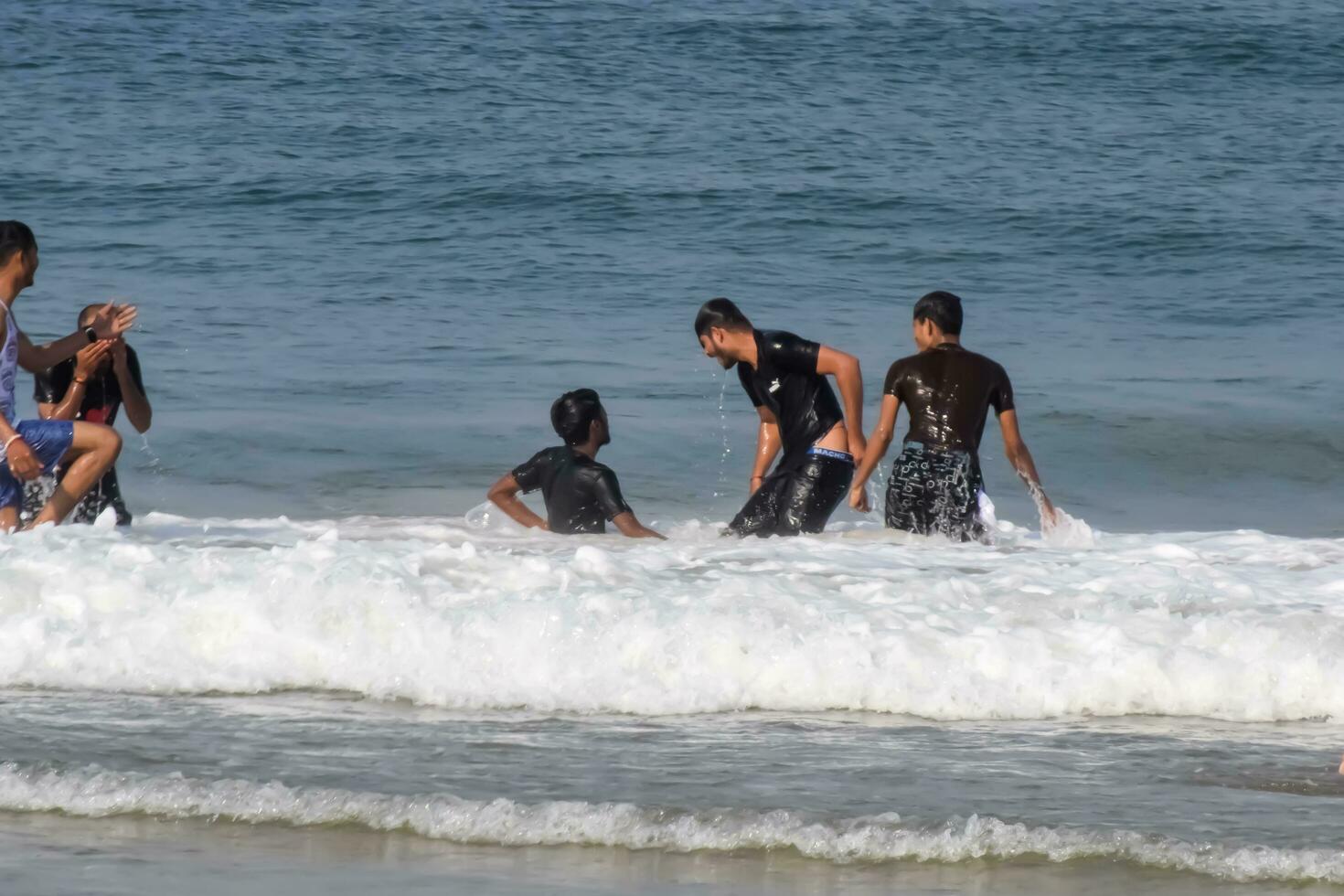 Goa, Índia, dezembro 10, 2023 - não identificado turistas desfrutando às árabe mar durante a manhã Tempo dentro calangute de praia Goa, Índia, oceano de praia Visão cedo manhã Tempo foto