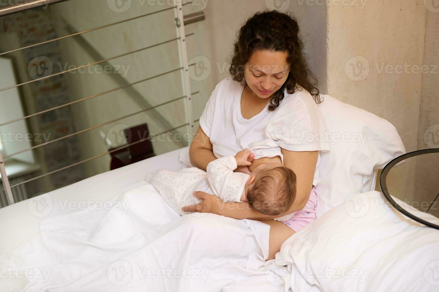 confiante jovem mulher mãe goza dela maternidade sair estilo de vida, amamenta dela bebê enquanto acorda acima dentro a manhã foto