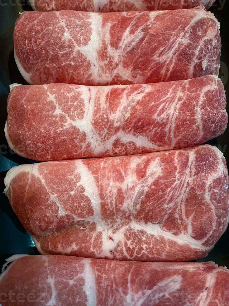 cru carne finamente fatiado para culinária. quente Panela ingredientes foto