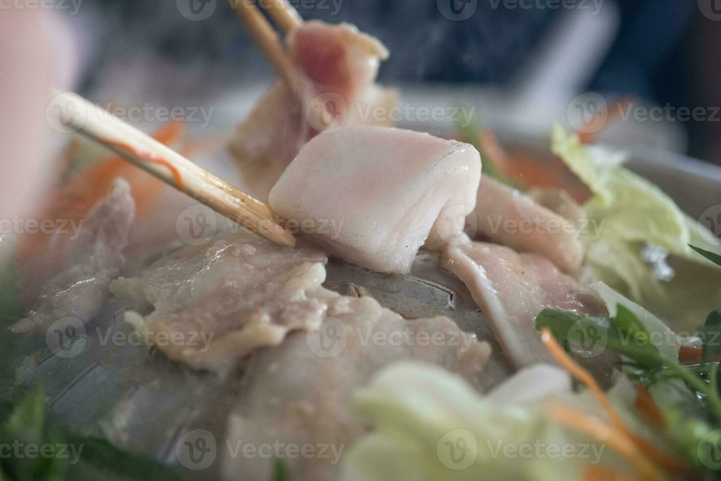 carne de porco em uma quente placa, você pode grade muitos coisas, 1 mordeu peça do cru carne de porco banha em a Centro do panela foto