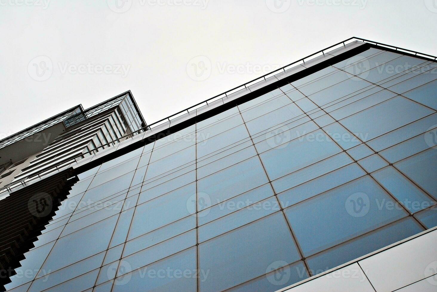 vidro construção com transparente fachada do a construção e azul céu. estrutural vidro parede refletindo azul céu. abstrato moderno arquitetura fragmento. contemporâneo arquitetônico fundo. foto