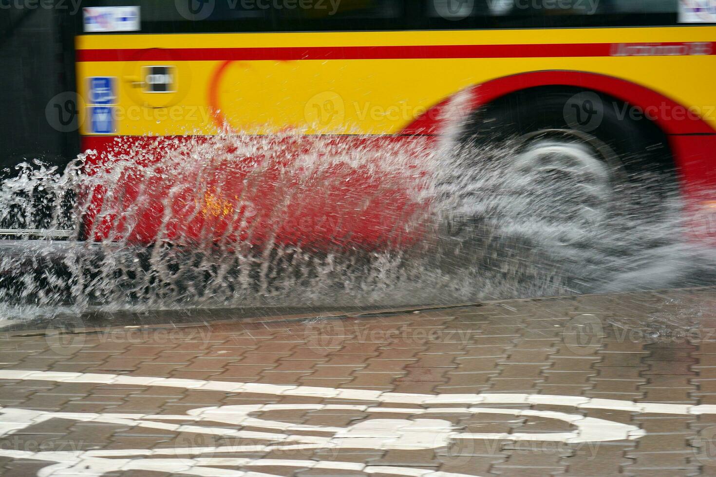 salpicos a partir de debaixo a rodas do a ônibus durante pesado chuva. borrado ônibus. foto
