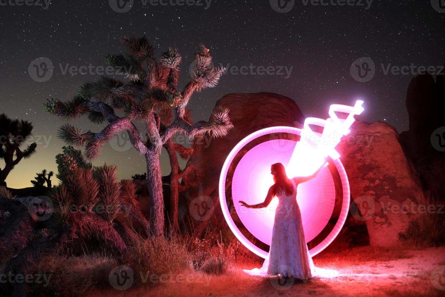 pessoa luz pintada no deserto sob o céu noturno foto