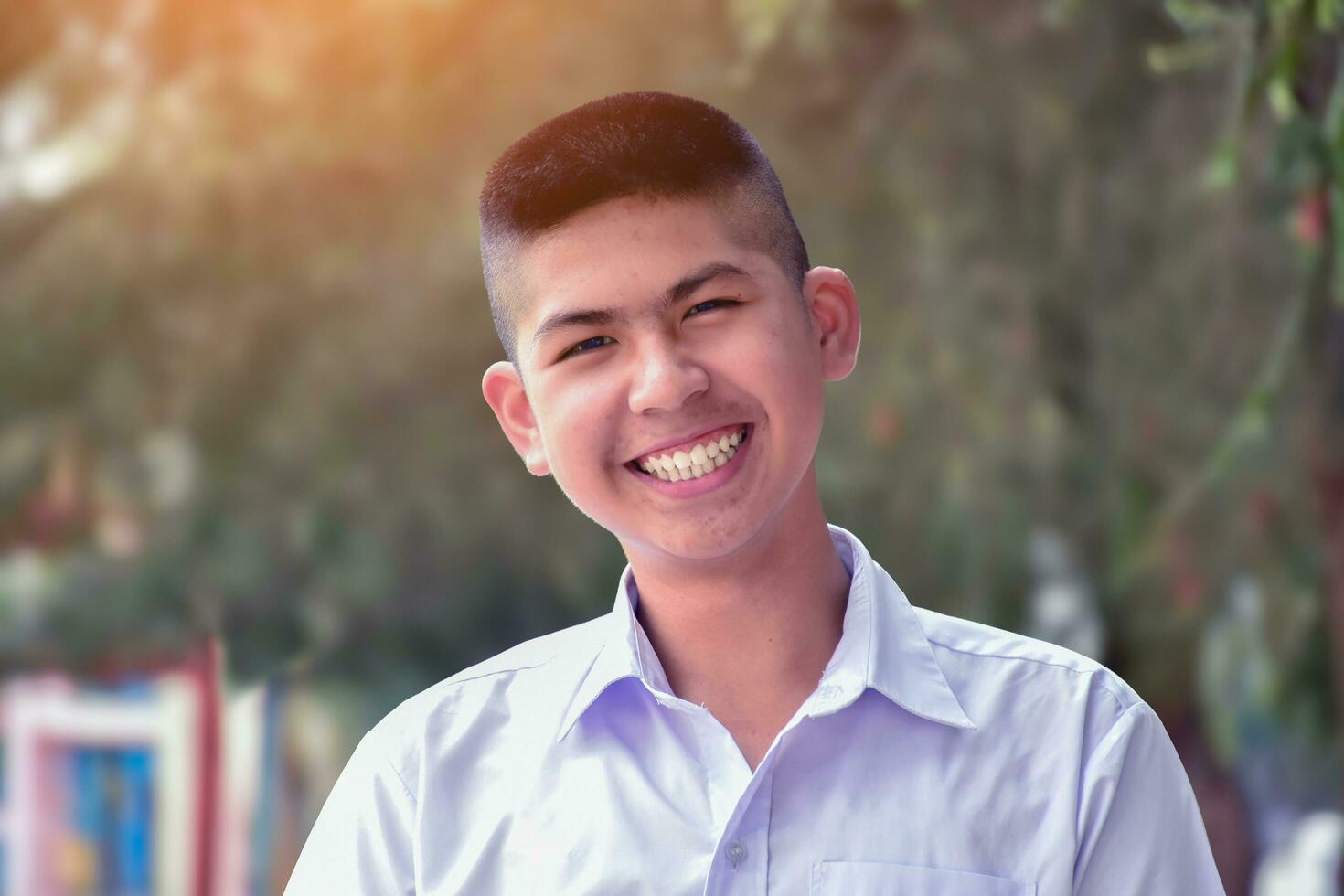 ásia fofa estudante que tem curto cabelo dentro branco escola uniforme e grande sorriso, suave foco, face e sorrir expressão do humano conceito. foto