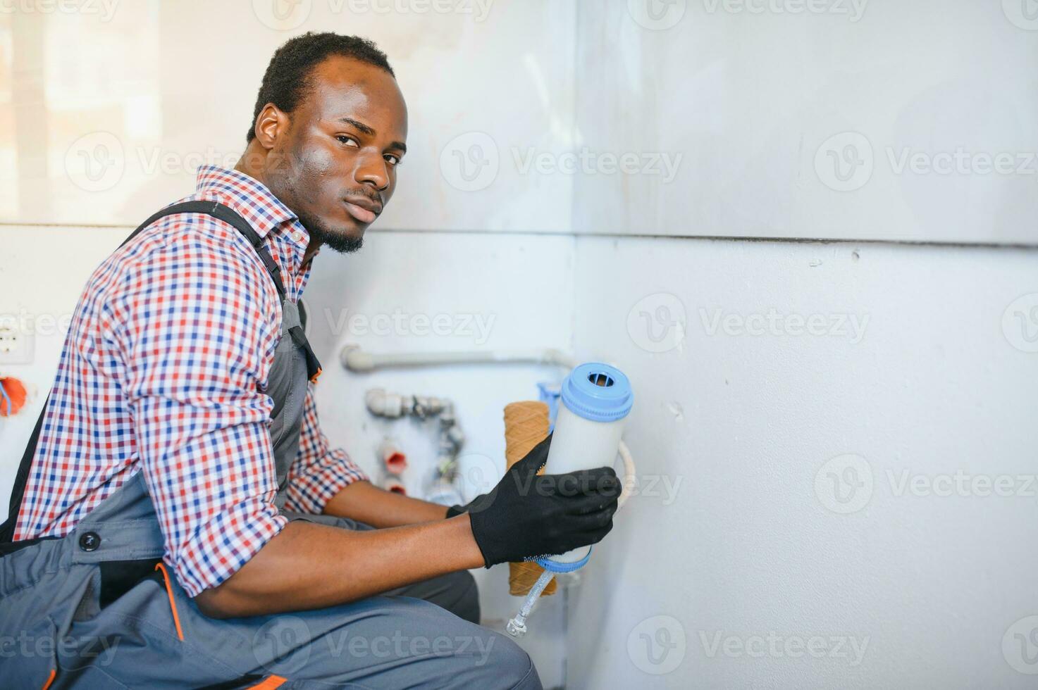 africano americano encanador instala uma água filtro. água filtro. foto