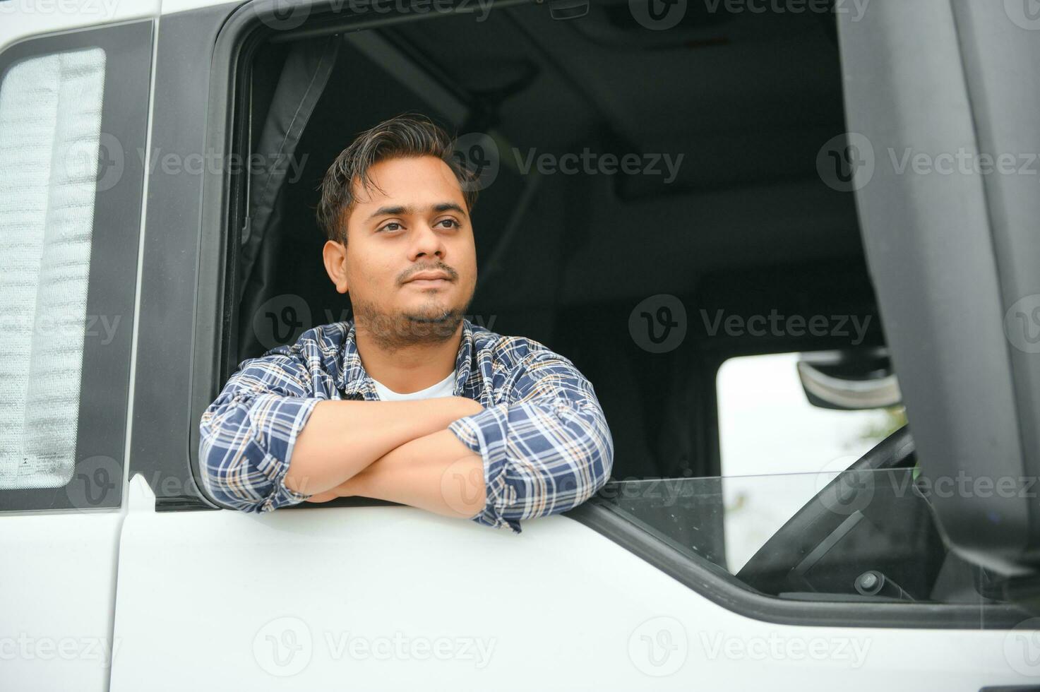 retrato do uma jovem bonito indiano caminhão motorista. a conceito do logística e frete transporte. foto