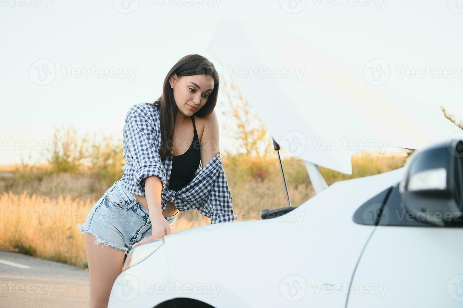 lindo sexy mulher perto uma quebrado carro. confuso mulher faz não conhecer o que para Faz foto