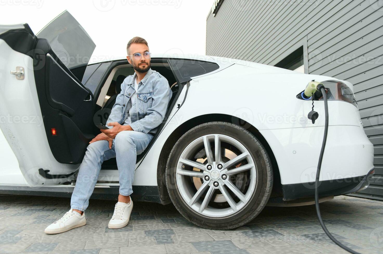 uma homem cobranças a elétrico carro foto