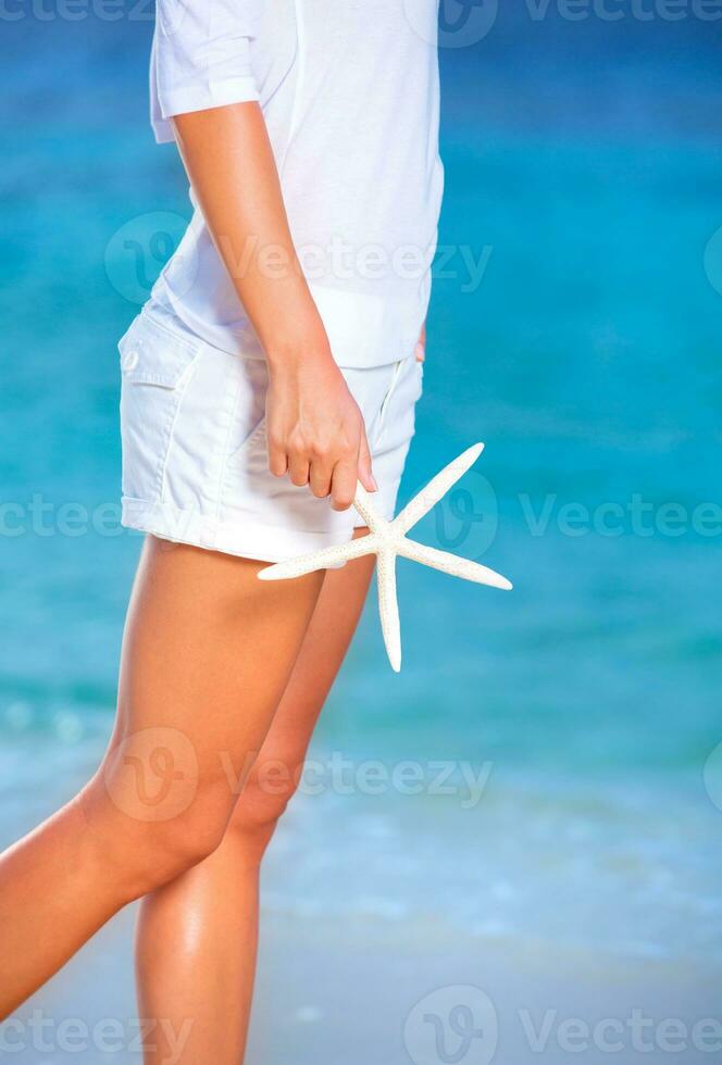mulher com estrelas do mar em a de praia foto