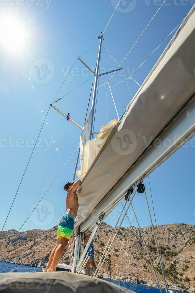 barco a vela equipe técnica dobrando a vela foto