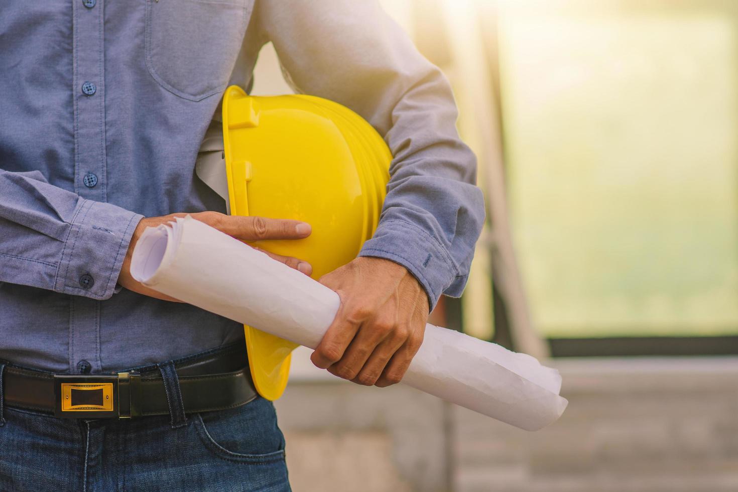 engenheiro de arquitetura segurando capacete no local de construção de fundo de construção foto