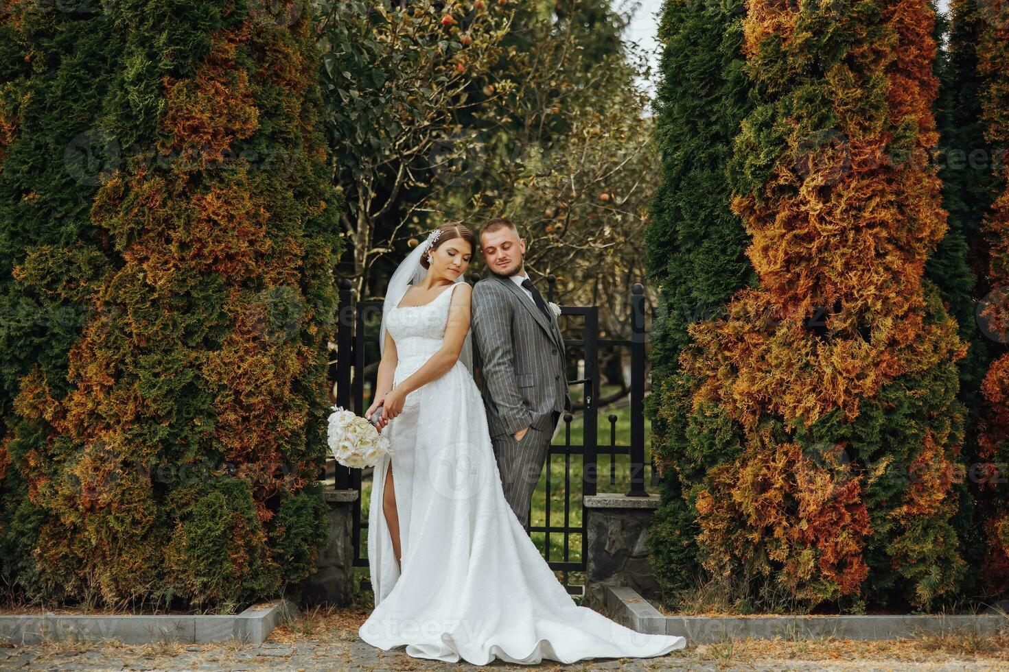 a noiva e noivo inclinou-se seus ombros dentro a parque. uma casal do recém-casados, a noiva e noivo, às uma Casamento dentro a natureza do verde árvores foto retrato Casamento casal