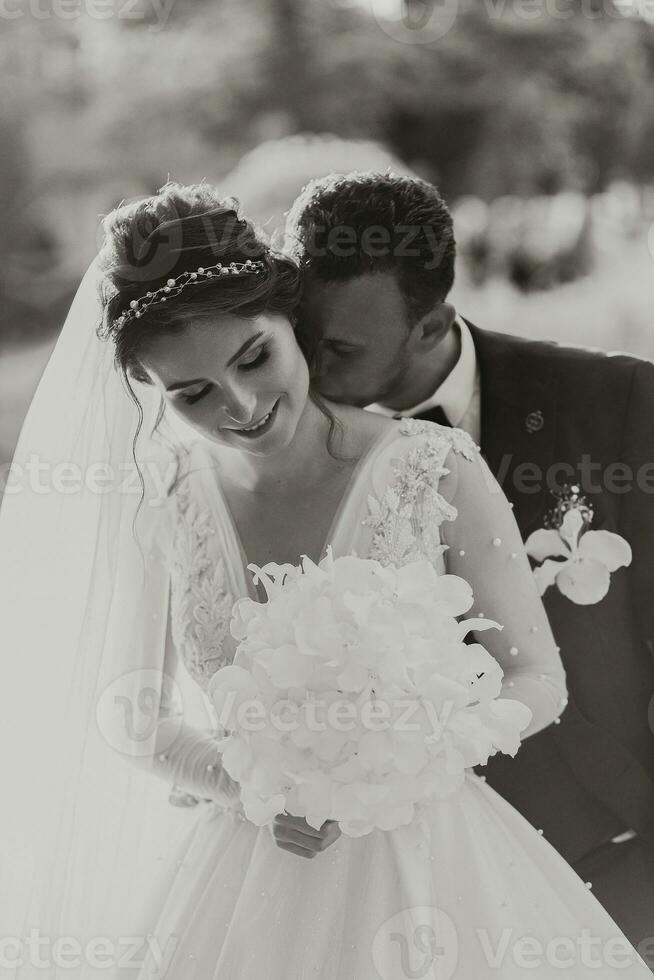 surpreendente sorridente Casamento casal. uma lindo noiva e uma à moda noivo. beijo do a noiva e noivo foto