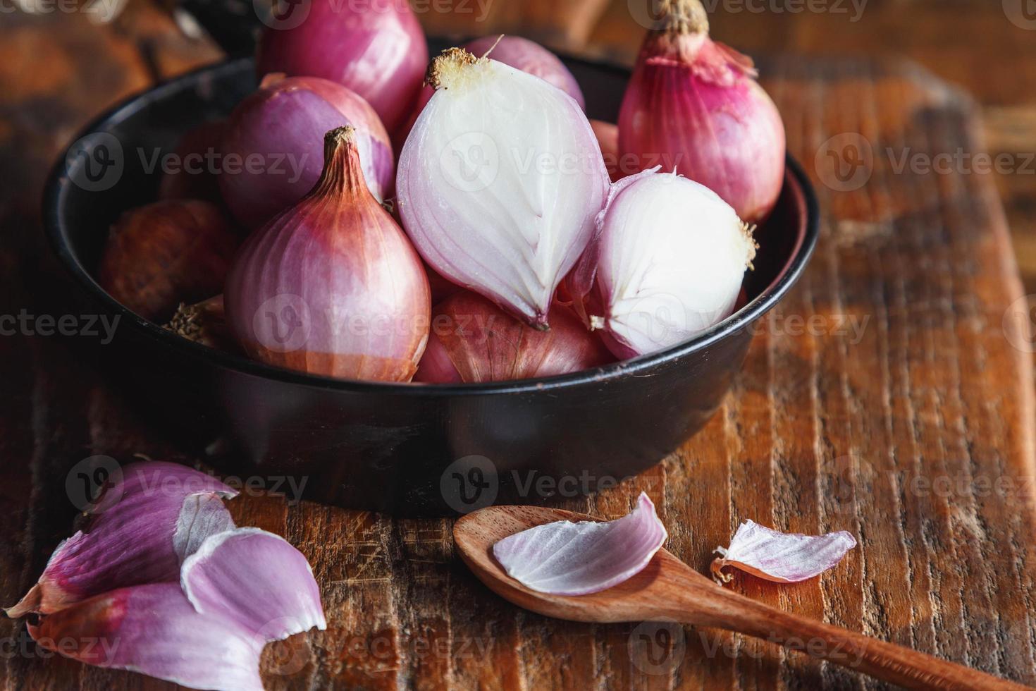 cebolas vermelhas frescas na panela na mesa da cozinha foto