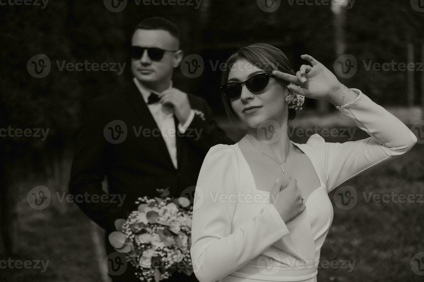 lindo Casamento casal. à moda noiva dentro Preto óculos dentro a primeiro plano. feliz Casamento foto do a noiva e noivo.